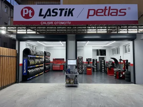 Dükkân girişi: Petlas tabelası ve lastik rafları