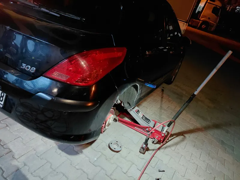 Yol kenarında kriko ile kaldırılmış otomobil